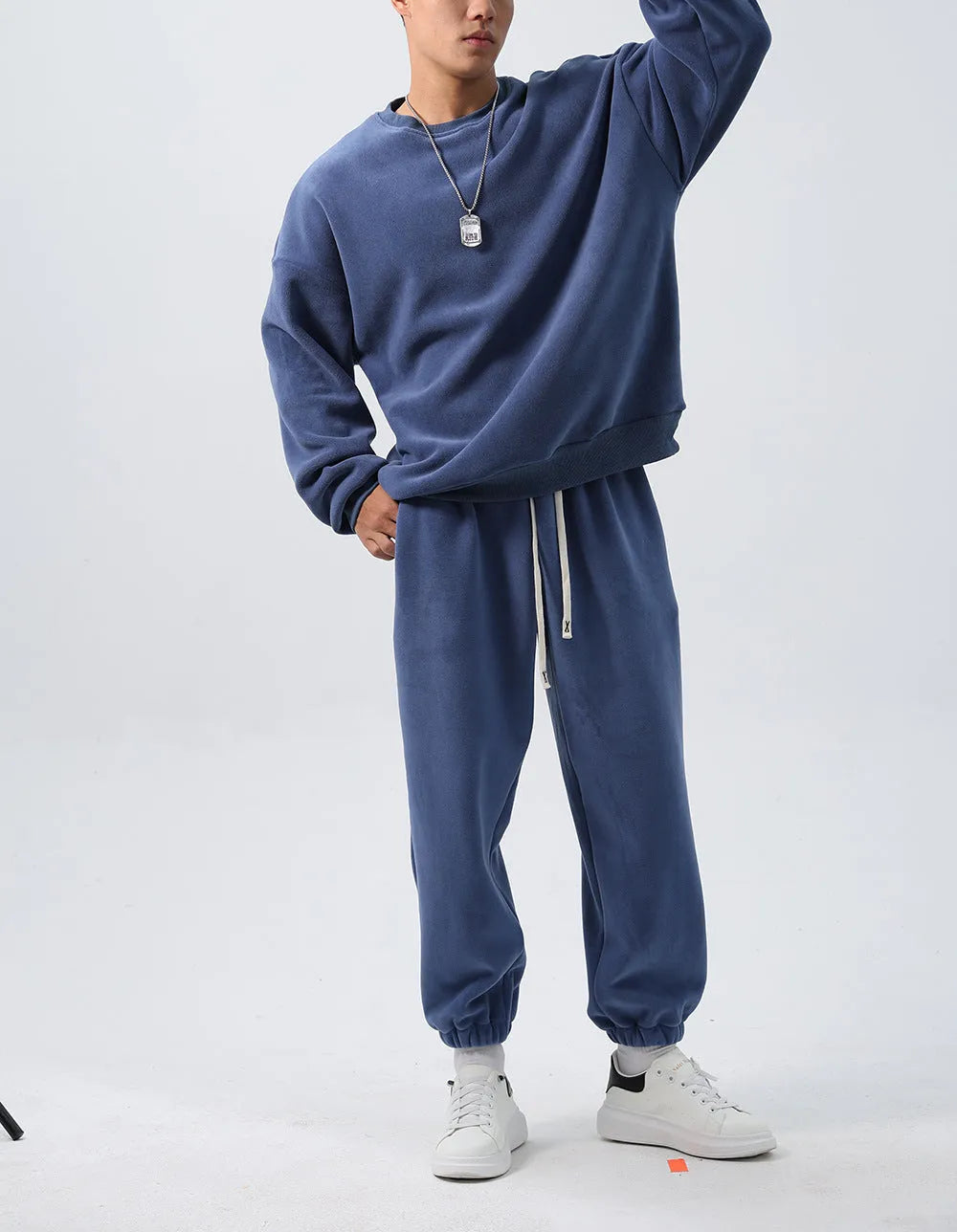 Men's loose-fit polar fleece sports suit in black, showing the long sleeve crew neck coat and matching padded trousers.