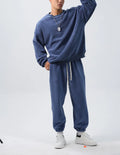 Men's loose-fit polar fleece sports suit in black, showing the long sleeve crew neck coat and matching padded trousers.