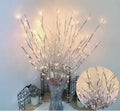 LED decorative tree light with silver branches in a vase, emitting coloured light.