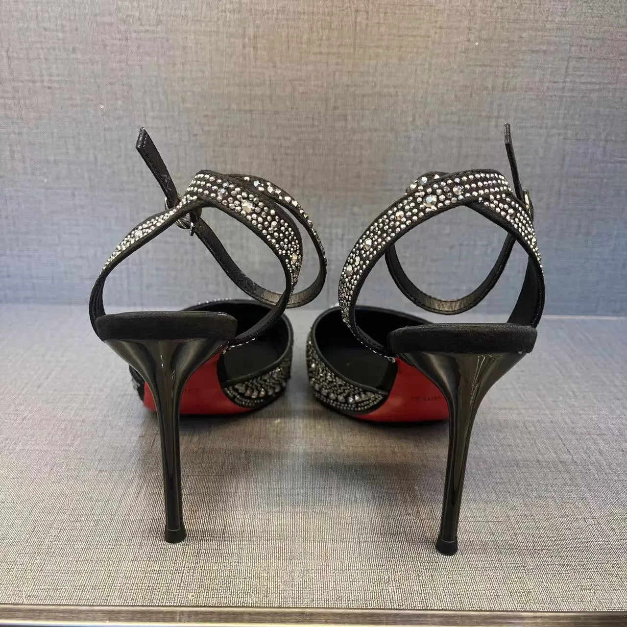 Women's black stiletto heels with pointed toe, hollowed design and red sole