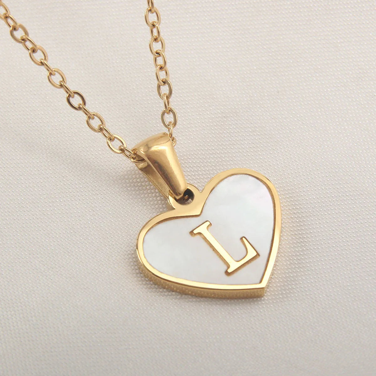 Gold plated initial necklace with white shell heart pendant and adjustable chain