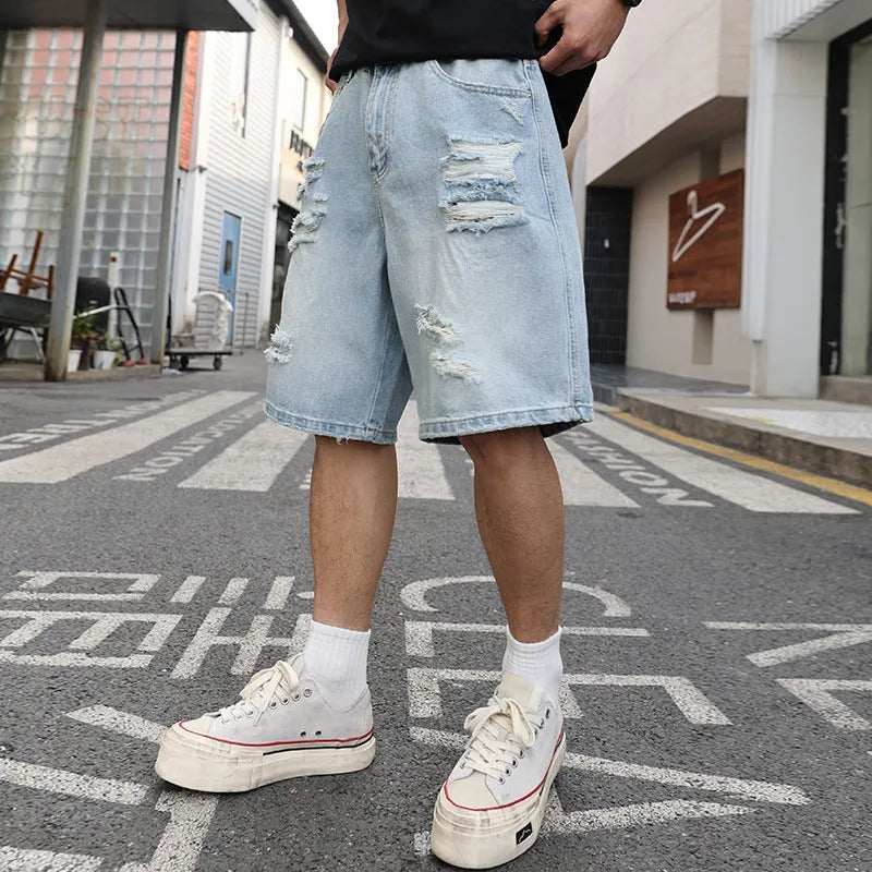 Light blue loose fit ripped denim shorts with distressed detailing and a straight leg cut