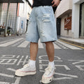 Light blue loose fit ripped denim shorts with distressed detailing and a straight leg cut
