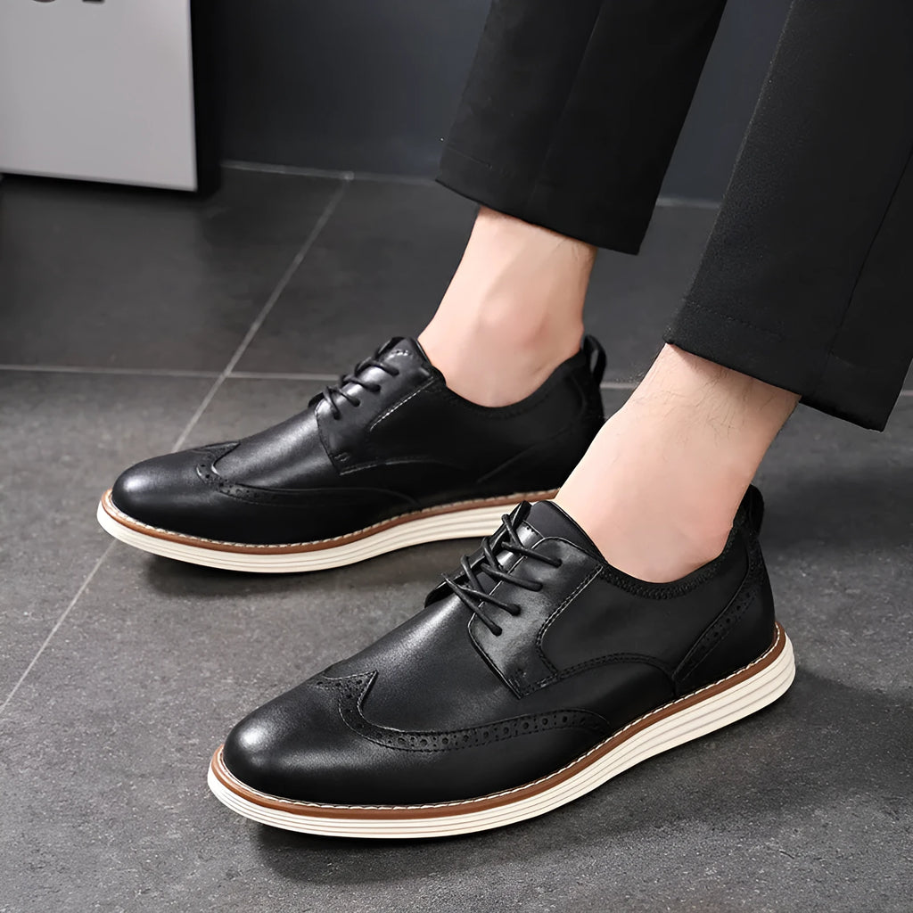 Men's black slip-on business casual shoes with decorative carving on the PU leather upper