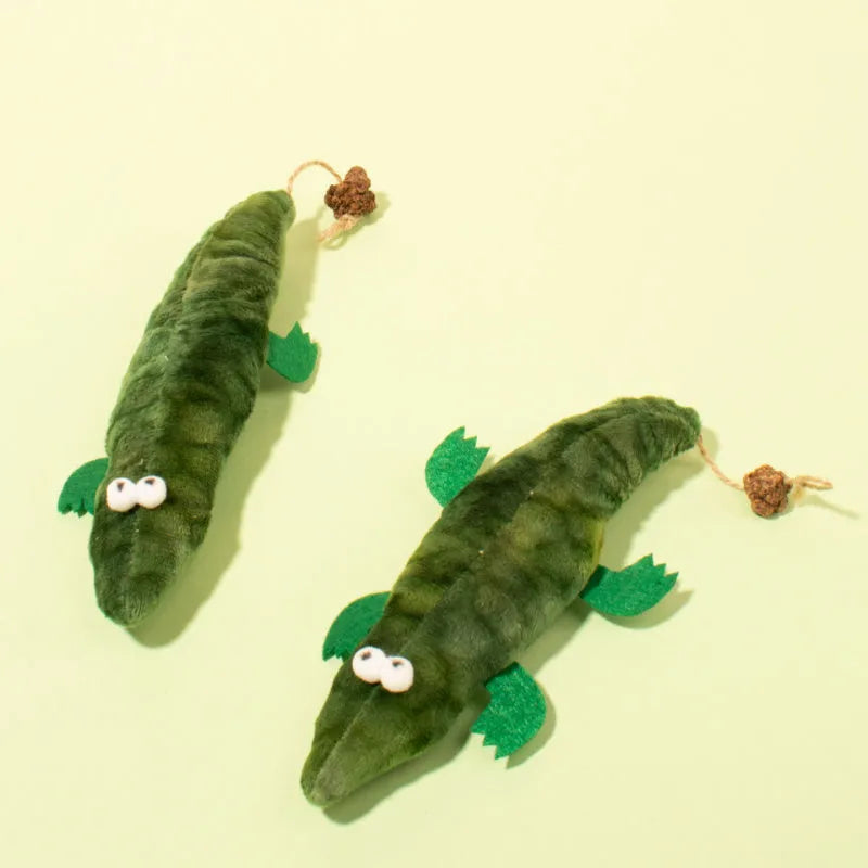 Green plush alligator catnip toy with embroidered eyes and nose