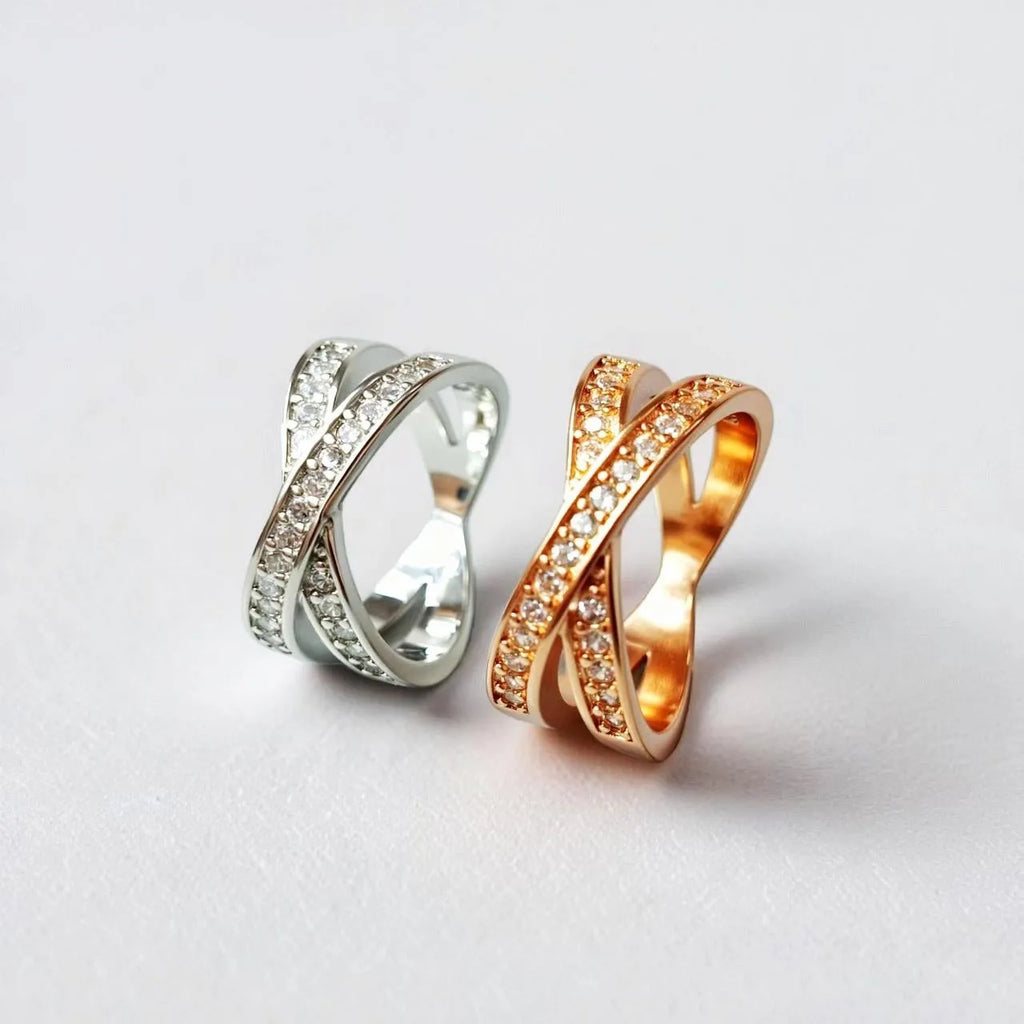 Silver and rose gold cross ring with micro-inlaid zircon stones on a simple geometric band.