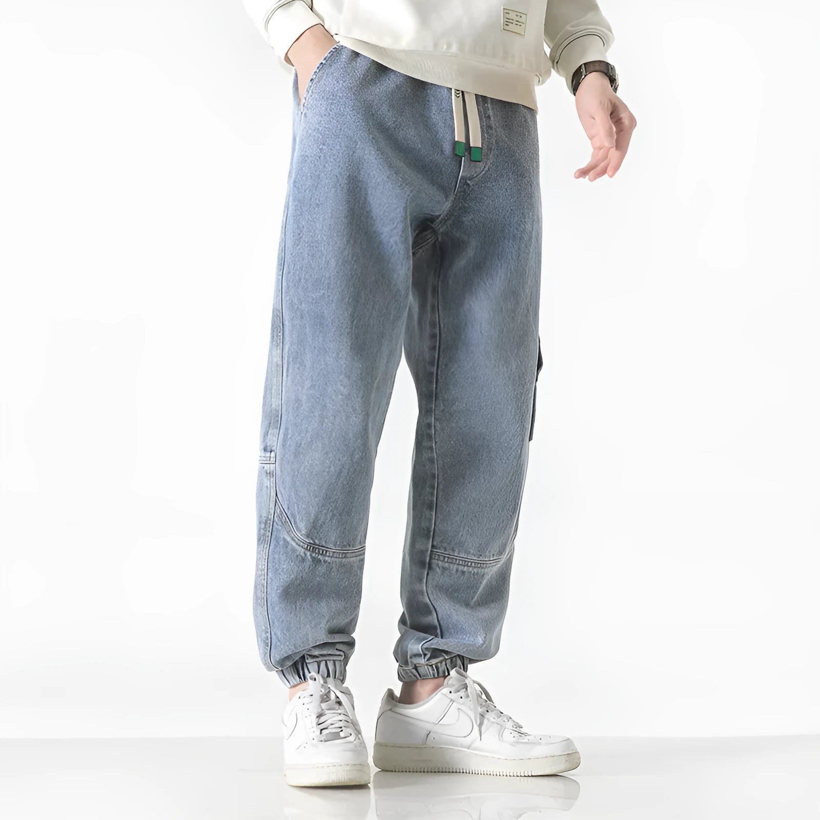 Men's loose-fit tapered cotton trousers in black, blue, or grey on a mid-waist.