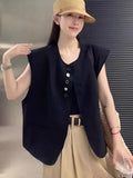 Women's loose fit sleeveless vest in black with a pocket, shown on a hanger.