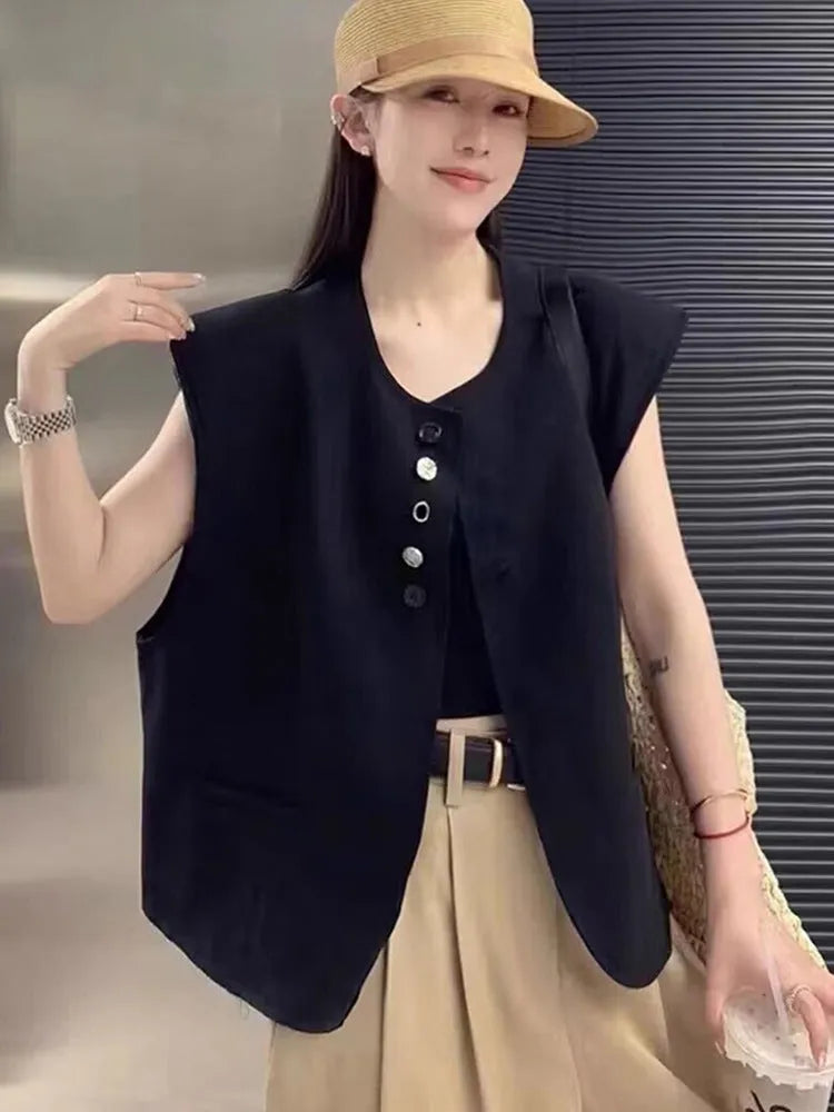 Women's loose fit sleeveless vest in black with a pocket, shown on a hanger.