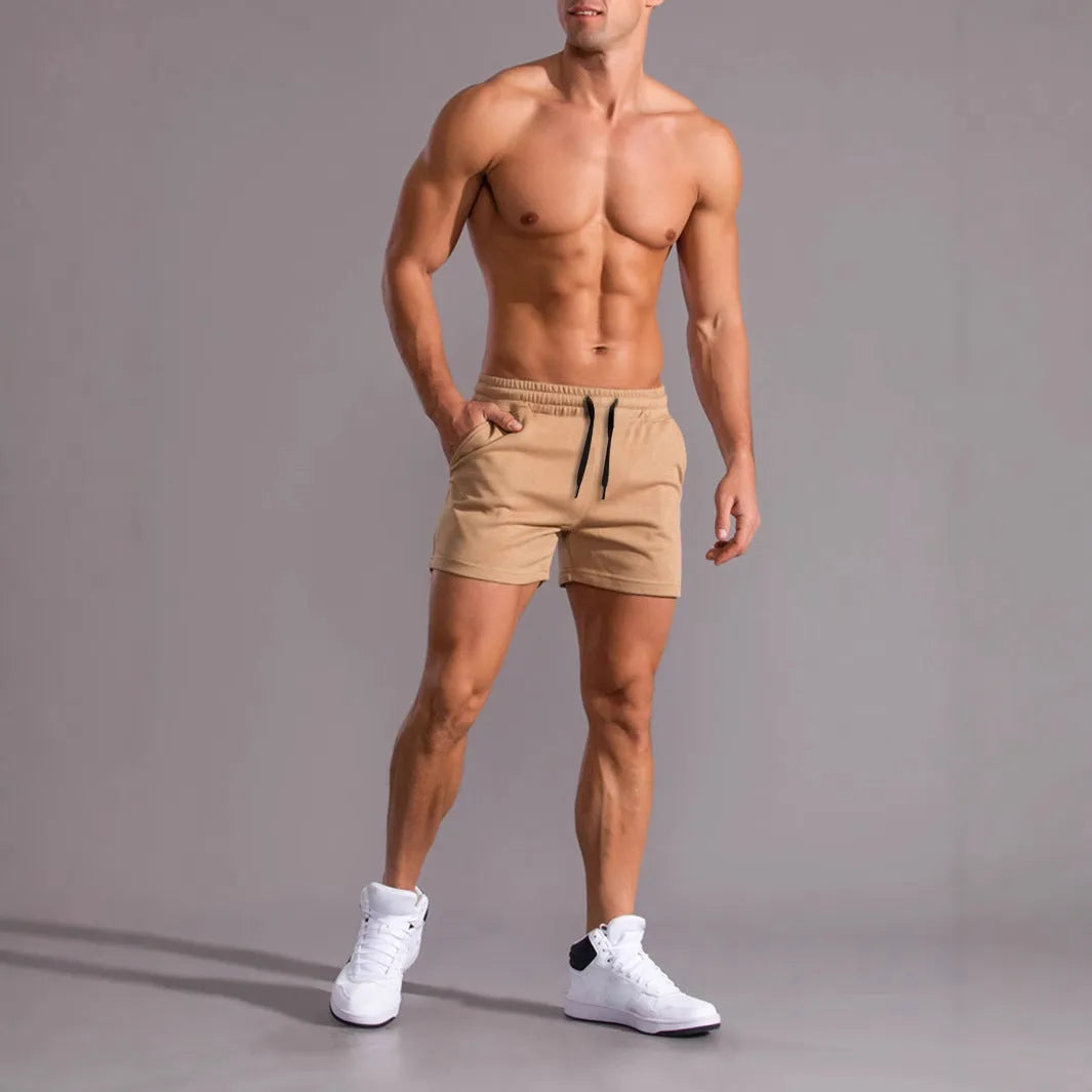 Three pairs of men's solid colour elastic shorts in black, khaki and light brown on a white background