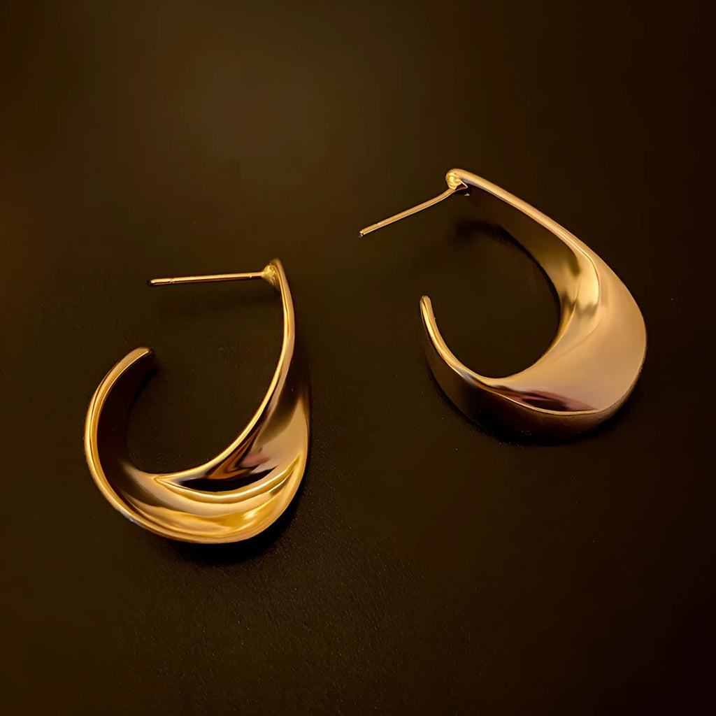 Geometric twisted metal earrings with round elements in gold or silver electroplated finish