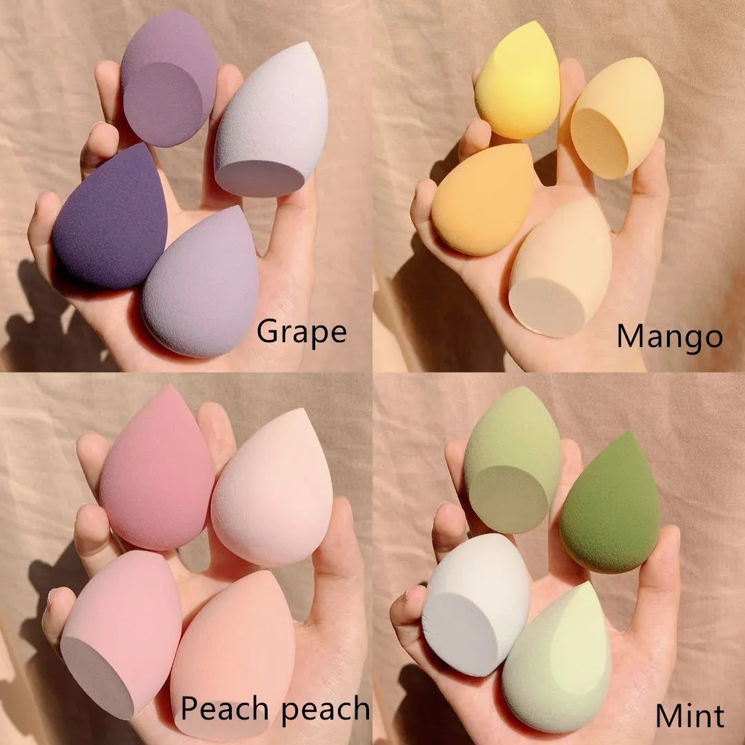 Box containing four coloured synthetic makeup sponges (grape, mango, mint, peach) each roughly 6cm in size.