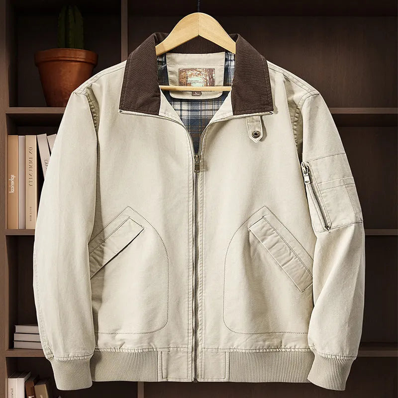 Men's beige washed cotton baseball style flight jacket on a hanger, showing classic design.