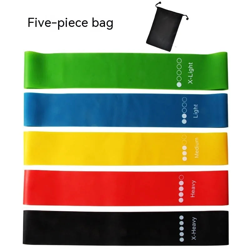 Five colour-coded yoga tension straps for resistance training laid flat showing green, blue, yellow, red, and black options