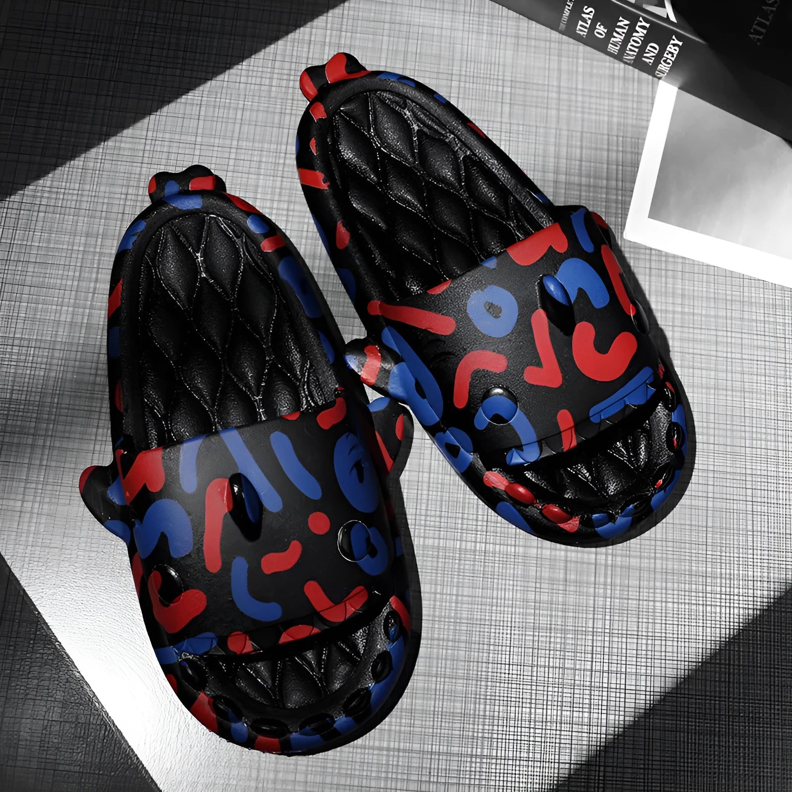 Pair of grey shark design open toe EVA home slippers on a white background.