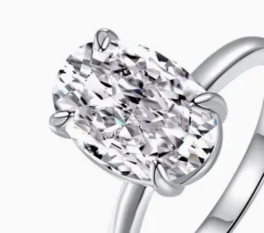 Women's oval 9K silver ring with a four-prong setting, shown in gold and silver tone finishes.
