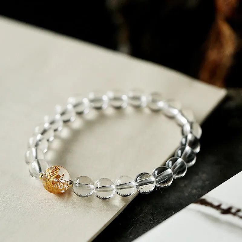 Geometric obsidian and white crystal unisex bracelet with a golden dragon bead on a wrist.