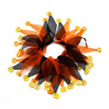 Colourful tie-dye cloth dog collar showing Christmas and Halloween patterns alongside green and blue solid colours.