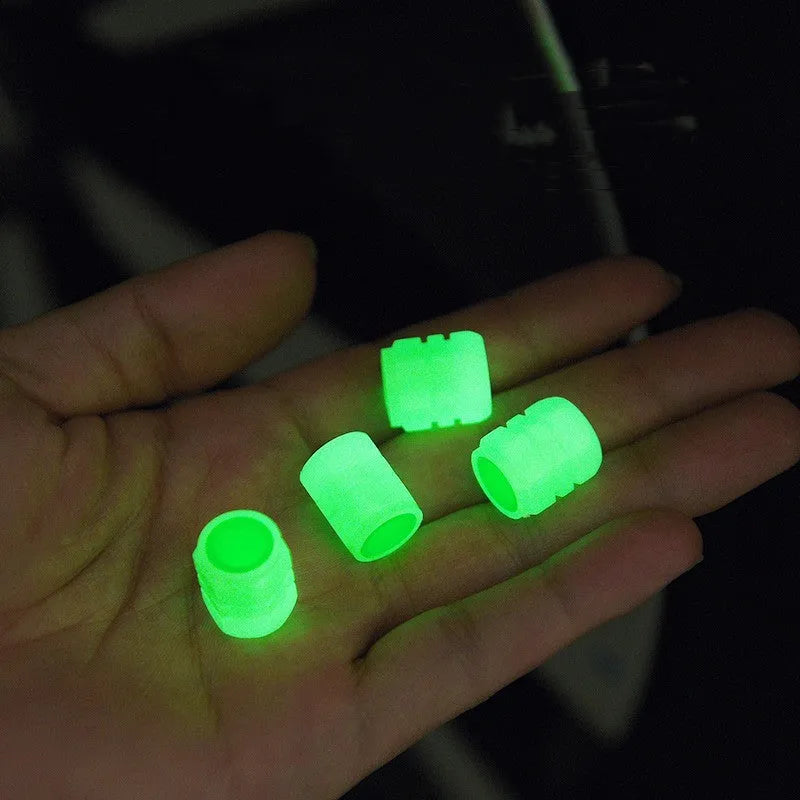 Set of four rubber luminous valve caps for car tyres on a dark background.