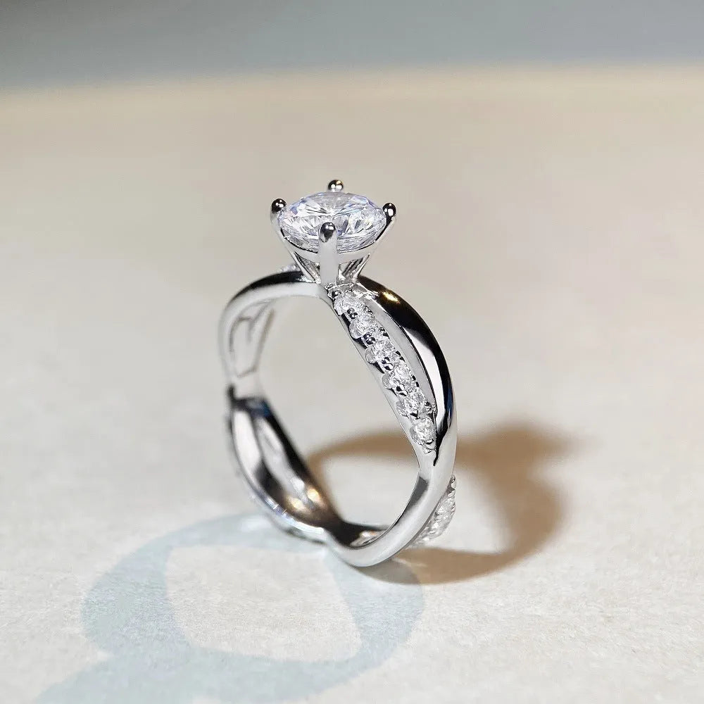 Silver ring with 1 karat moissanite stone in four-claw setting and twisted geometric arms