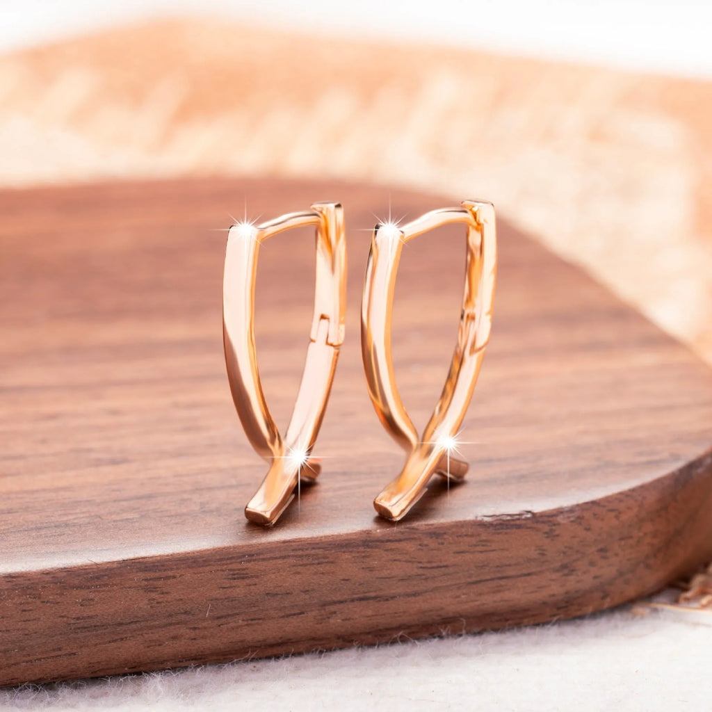 Rose gold cross shaped earrings made from copper with geometric design