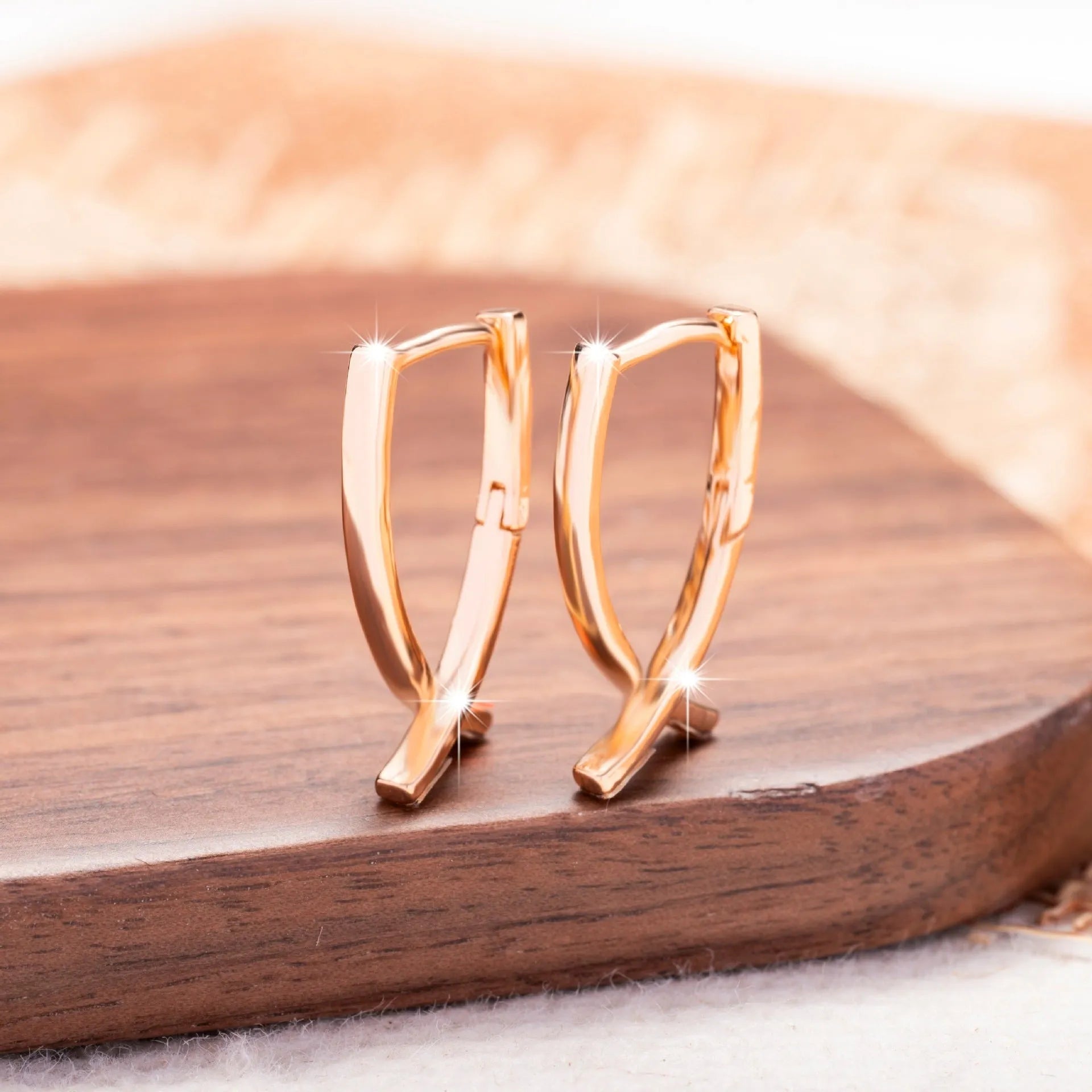 Rose gold cross shaped earrings made from copper with geometric design