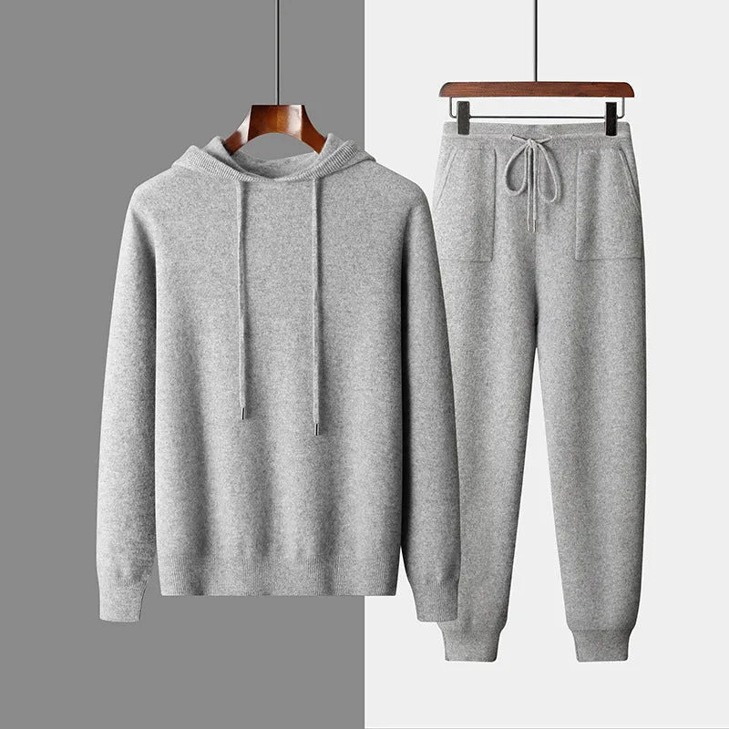 Men's light grey hooded cashmere sweatshirt and matching long pants laid flat as a complete casual winter set.