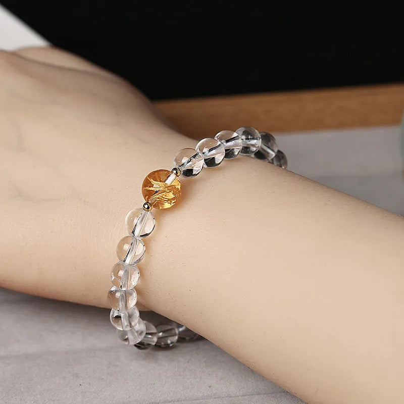 Geometric obsidian and white crystal unisex bracelet with a golden dragon bead on a wrist.