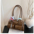Black retro women's pillow-shaped handbag with double shoulder strap and flap closure.