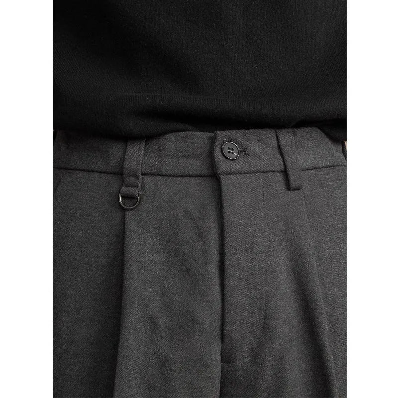 Men's straight-leg casual trousers in black, shown in a light business style setting.