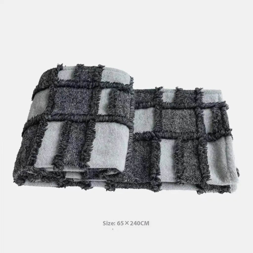 Modern minimalist grey and white plaid bed runner blanket with matching pillowcase and round leather pillow