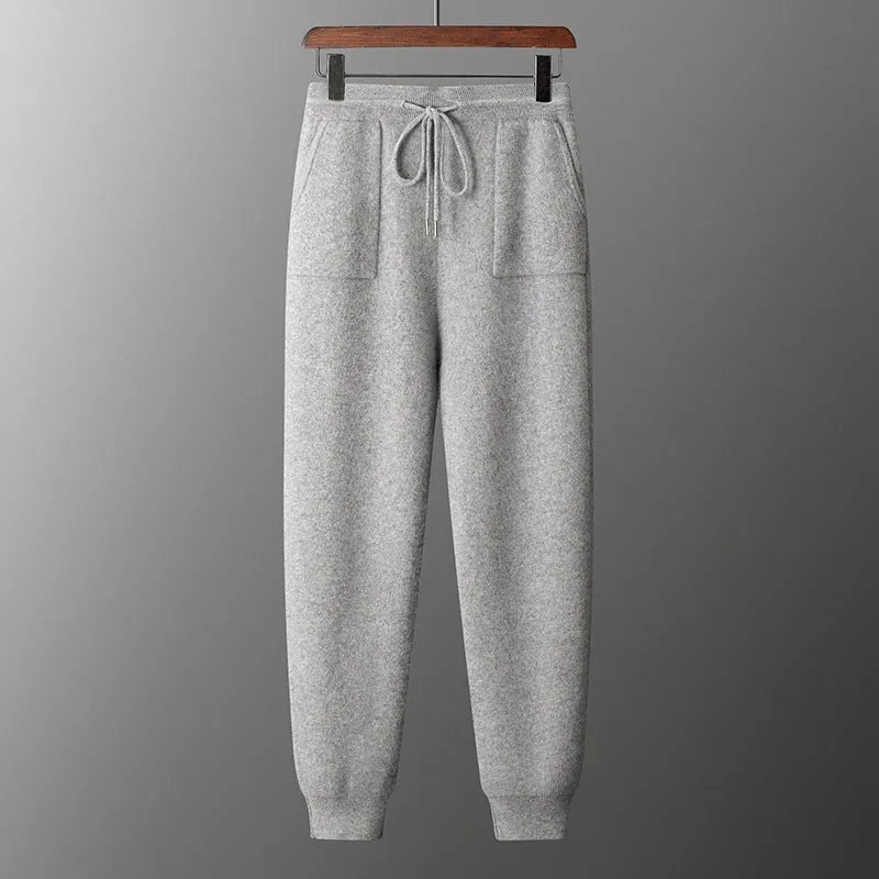 Men's light grey hooded cashmere sweatshirt and matching long pants laid flat as a complete casual winter set.