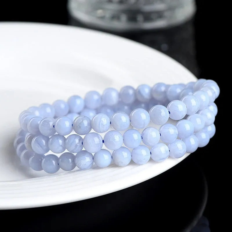 Blue multi-circle patterned agate bracelet with scattered 6-6.8mm beads and Ruyi design detail on a white background.