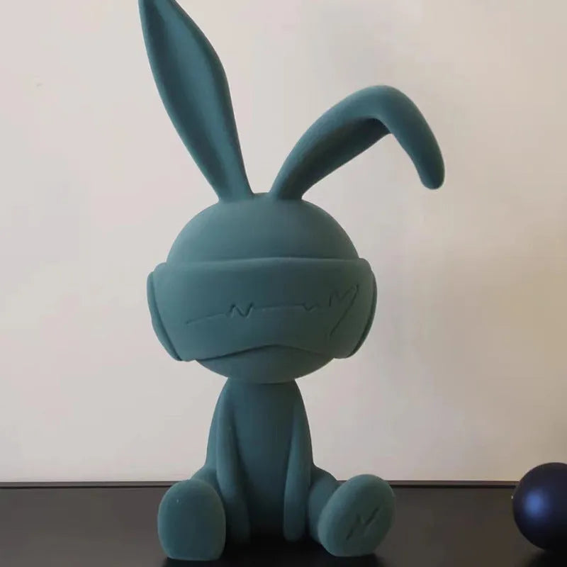 Green suede blindfold rabbit resin table ornament on a wooden desk