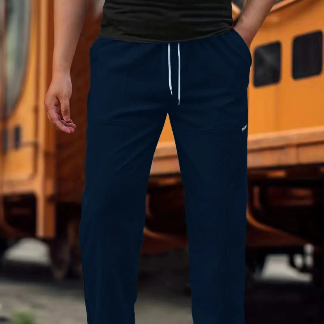Men's polyester trousers in light grey, shown flat, with a size label indicating S-XXXL range.