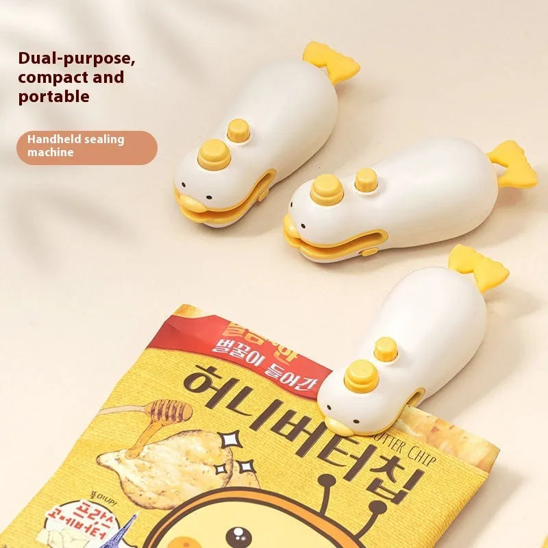 Small yellow duck-shaped rechargeable handheld sealing machine with USB charging cable.