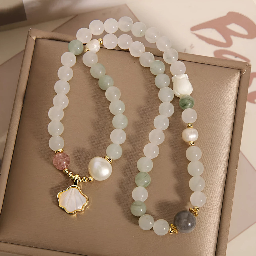 Women's emerald green crystal bracelet with gold ginkgo leaf pendant and rhinestone accents