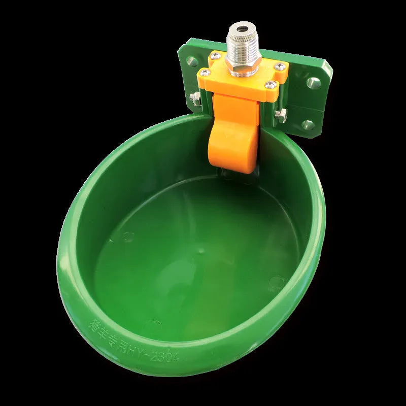 Green engineering plastic auto-drink water bowl for pigs and sheep on a farm.