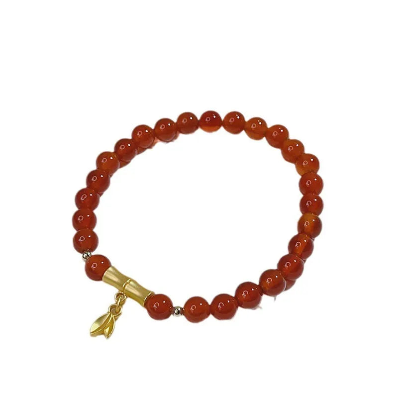 Women's red agate bracelet with manual Chinese dragon and lucky bag designs.