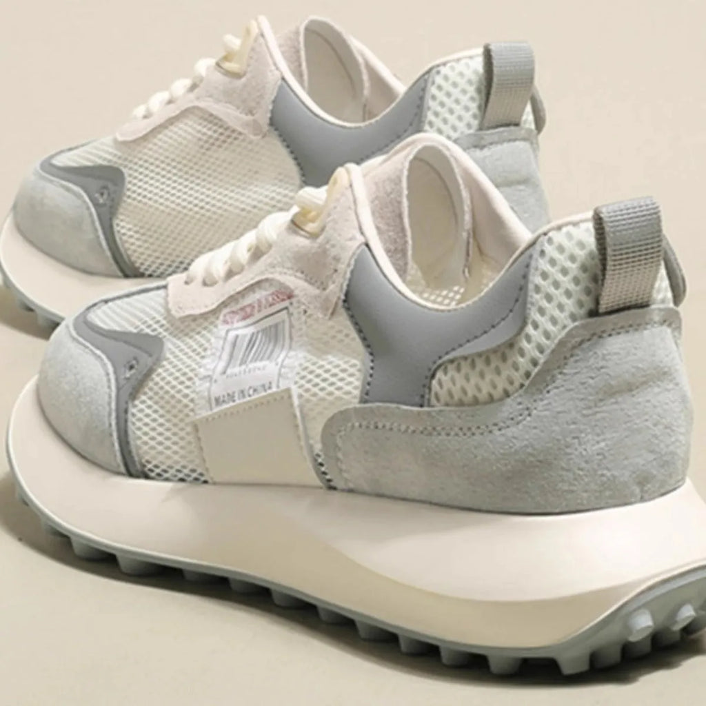 Women's grey and pink retro low-top sneaker with round toe and rubber sole.