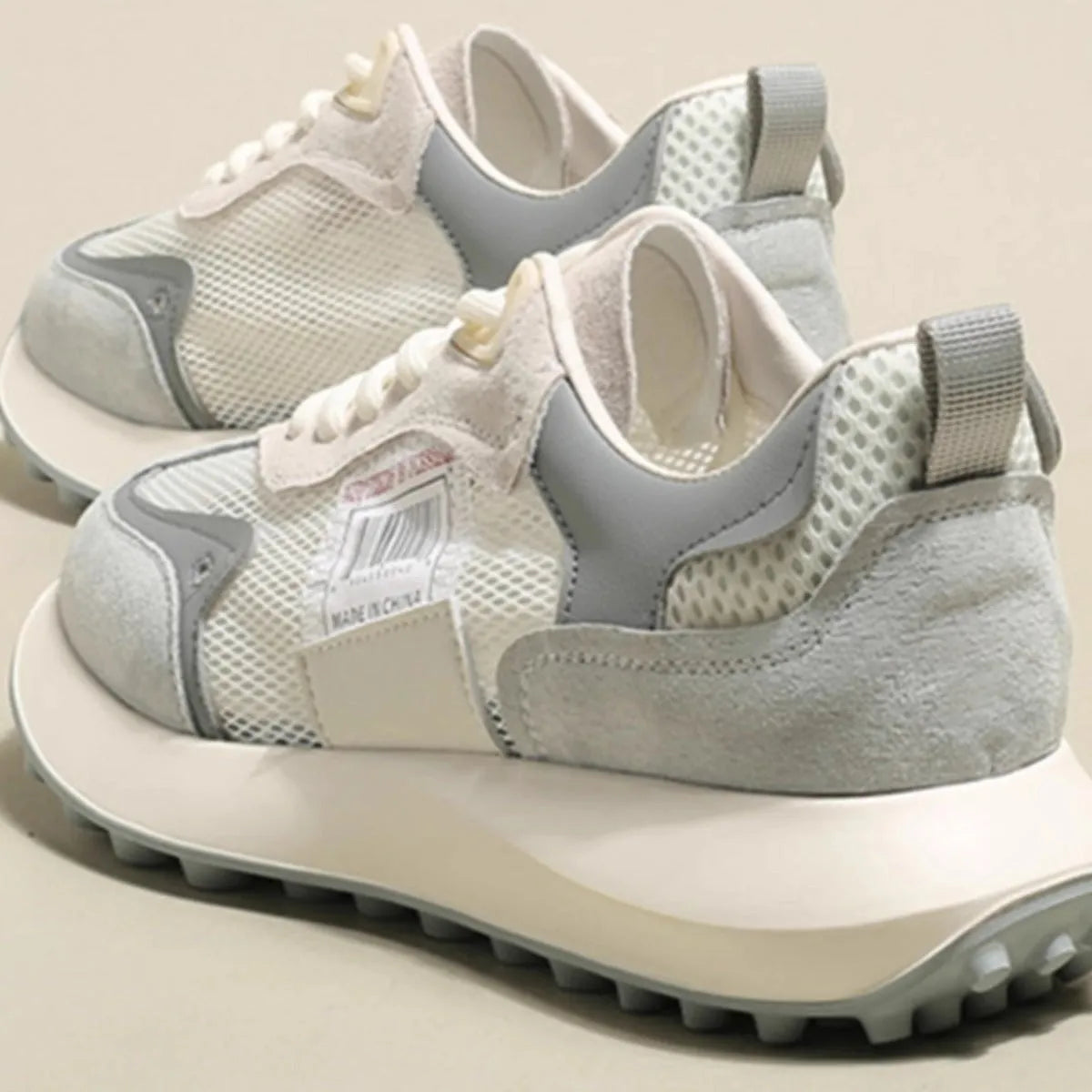Women's grey and pink retro low-top sneaker with round toe and rubber sole.