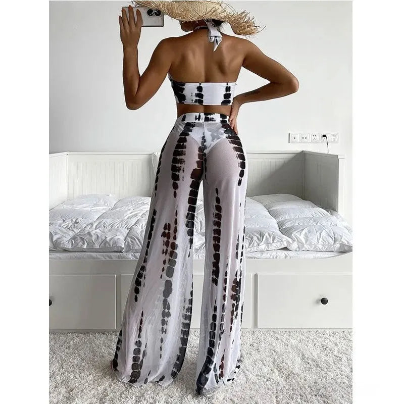 Women's black printed three-piece swimsuit set with mesh trousers, bikini top, and briefs.