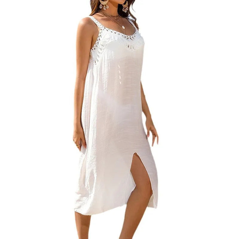 White crocheted beach dress on a hanger, showing hollow weave detail and a side slit.