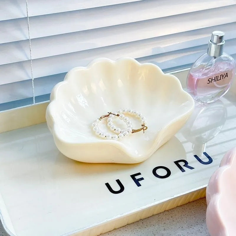White and pink shell-shaped plastic soap dish on a bathroom countertop