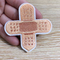Embroidery detail on iron-on clothing patch with adhesive backing visible