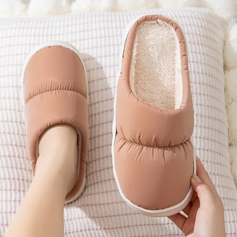 A pair of thick-soled plush slippers with artificial leather uppers and non-slip rubber soles in a choice of five colours.
