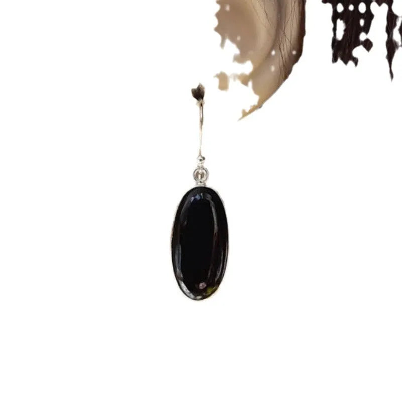 Women's earrings with black oval agate pendant and silver electroplated geometric Chinese style design.