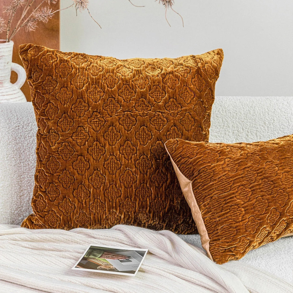 Brown gold antique-style quilted square cushion pillow on a grey sofa.