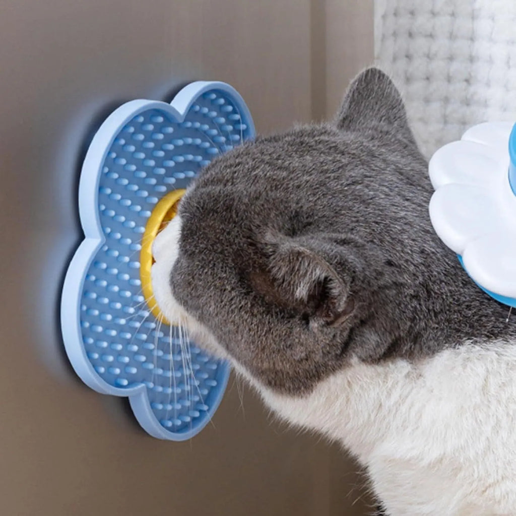 Flower-shaped blue silicone pet licking mat with suction cups on a smooth surface.