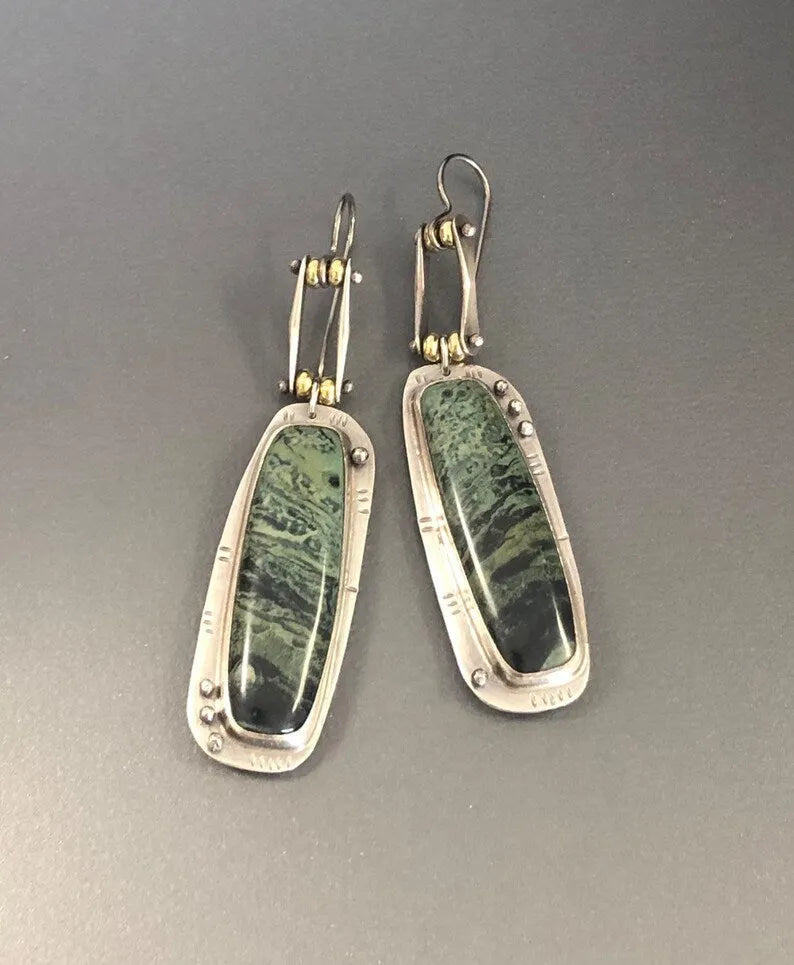 A pair of geometric-shaped alloy earrings with a black and white marble pattern print.